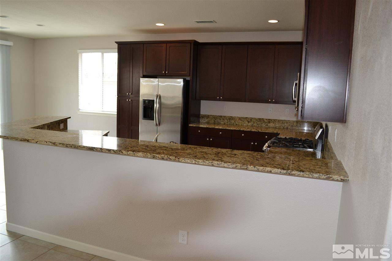 10790 Ridgebrook Drive Reno, NV 89521 - Photo 5 of 16 a kitchen with stainless steel appliances granite countertop a sink a stove and a refrigerator with wooden floor