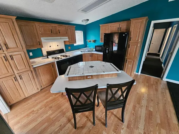 a kitchen with a table chairs refrigerator and microwave