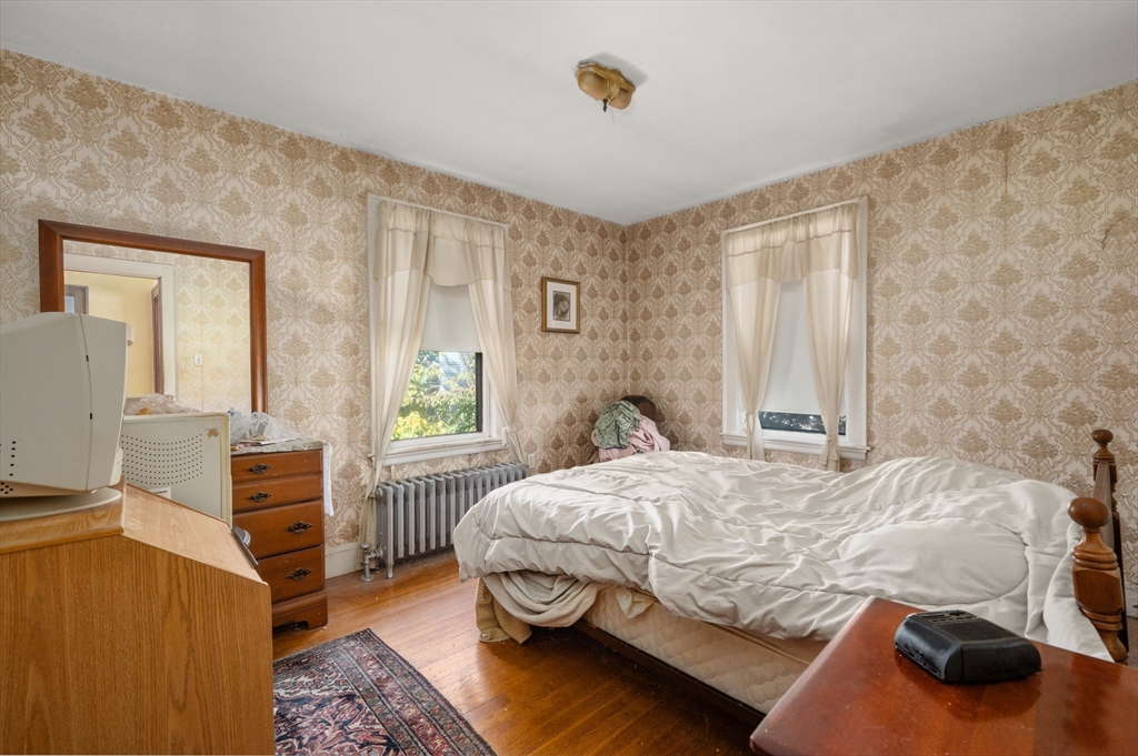 73 Woodard Road Boston, MA 02132 - Photo 9 of 20 a bedroom with a bed and wooden floor