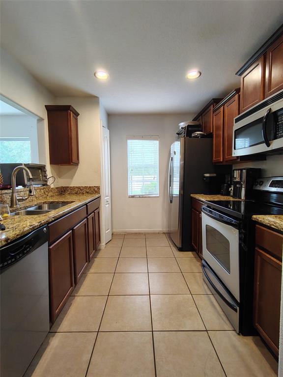 9871 Trumpet Vine Loop Trinity, FL 34655 - Photo 8 of 10 a kitchen with stainless steel appliances granite countertop a stove a sink and a microwave