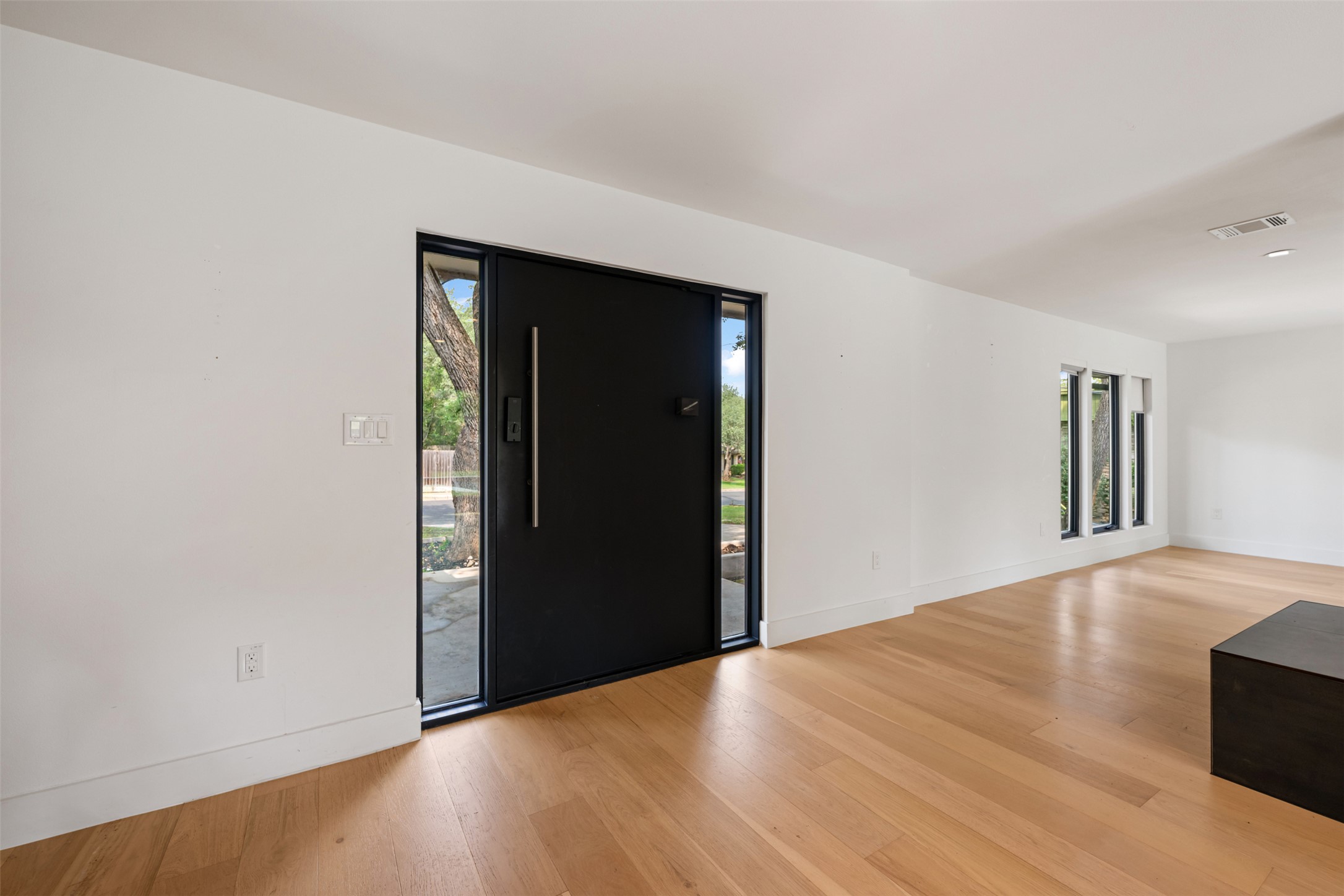 8900 Point W Drive Austin, TX 78759 - Photo 4 of 40 A modern entry with a striking black door and bright wood floors welcomes you home.