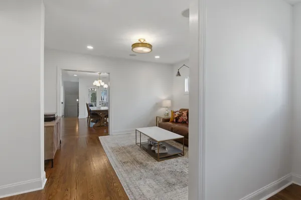 a hallway with a view of bedroom with wooden flooring