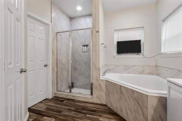 a bathroom with a tub a window and a shower
