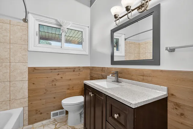 a bathroom with a sink a toilet and a mirror