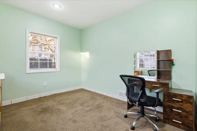 a view of a workspace with furniture and a window