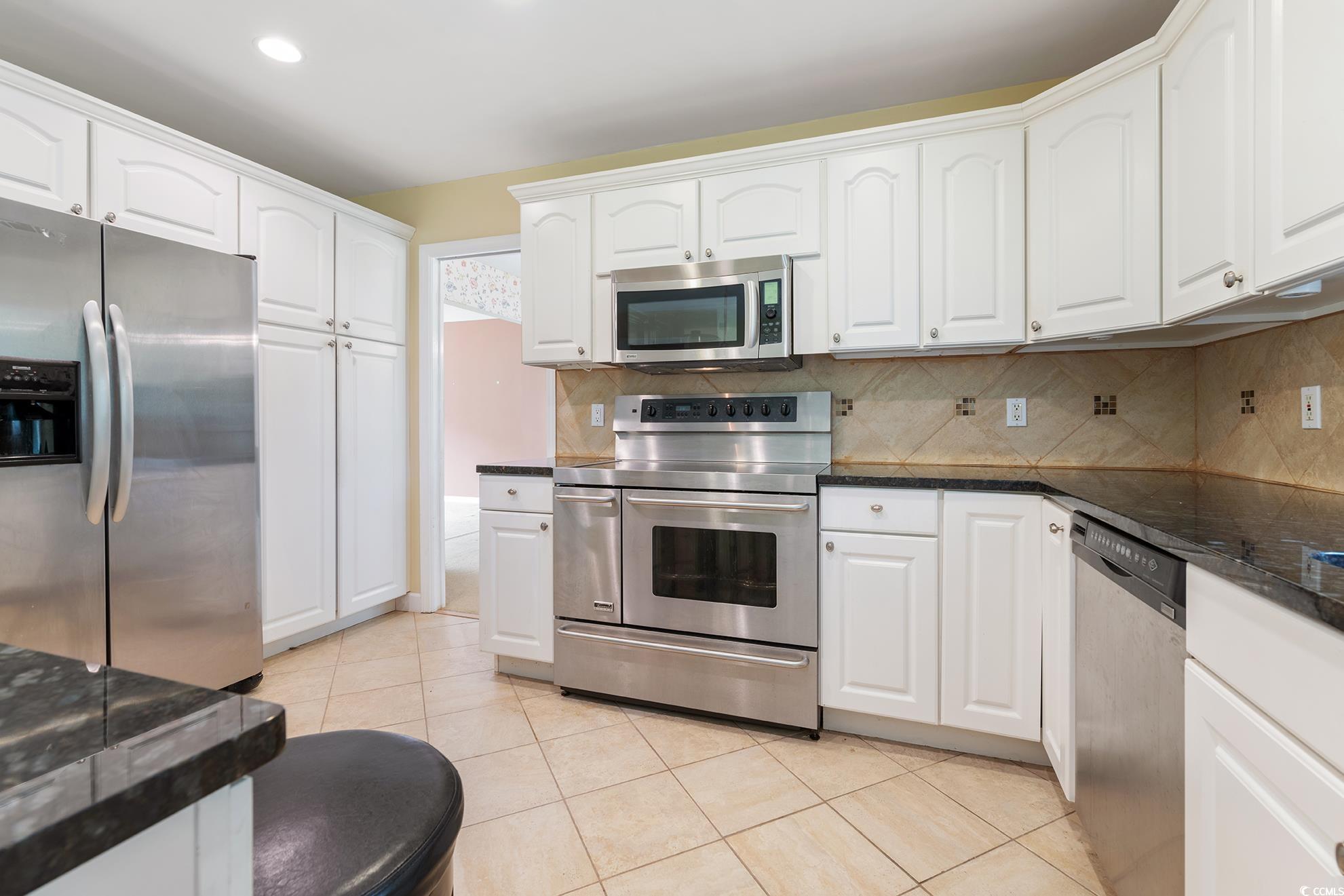 1002 Pyatt Street Georgetown, SC 29440 - Photo 16 of 30 Kitchen with dark stone counters, white cabinets,