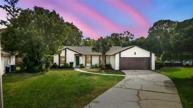 a front view of a house with a yard and trees