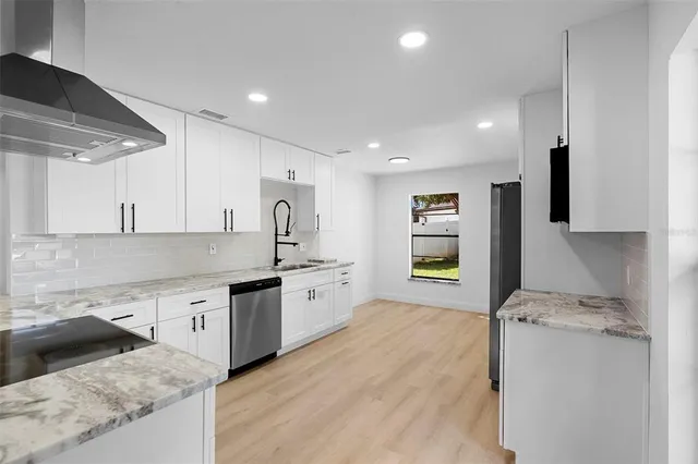 an aerial view of residential houses with outdoor space and trees