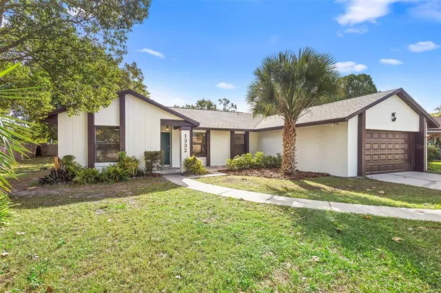 a kitchen with stainless steel appliances kitchen island granite countertop a refrigerator a sink a stove and white cabinets with wooden floor