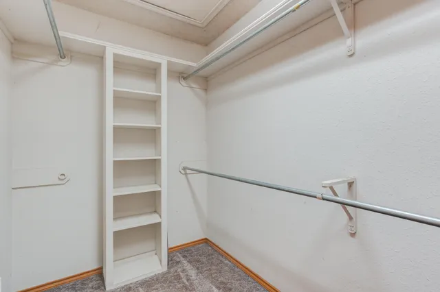a view of walk in closet with empty racks