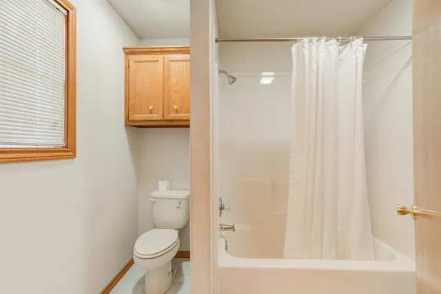 a bathroom with a toilet and a shower curtain
