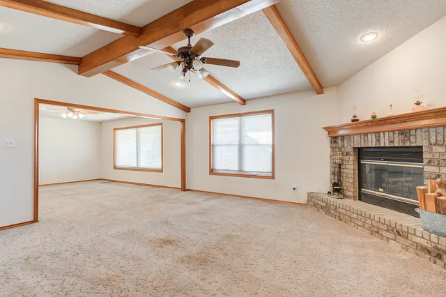 an empty room with windows and fireplace