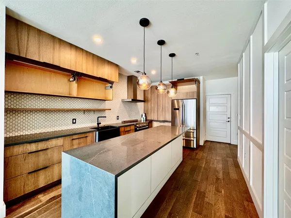 a kitchen with stainless steel appliances granite countertop a sink a stove and a refrigerator
