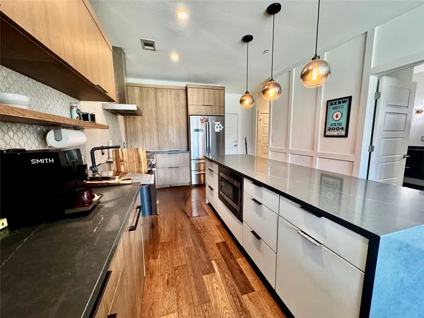 a kitchen with stainless steel appliances granite countertop sink stove refrigerator and cabinets