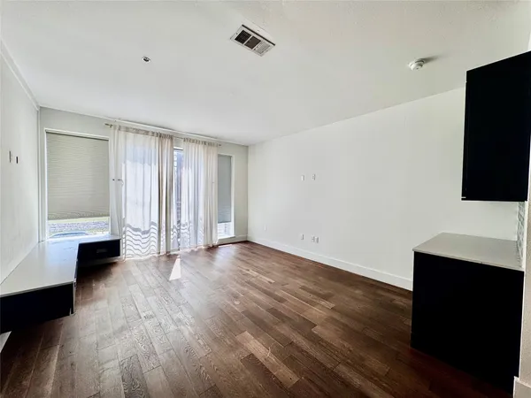 a view of a livingroom with wooden floor and a fireplace