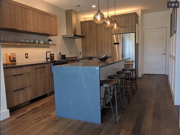 a kitchen with kitchen island granite countertop wooden floors and stainless steel appliances