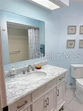a bathroom with a granite countertop sink and a mirror