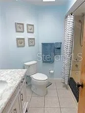 a bathroom with a granite countertop toilet and a sink