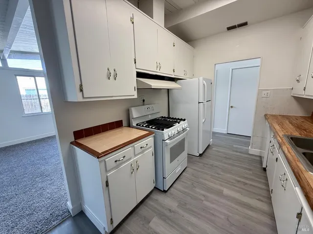 a kitchen with stainless steel appliances granite countertop a sink stove and cabinets