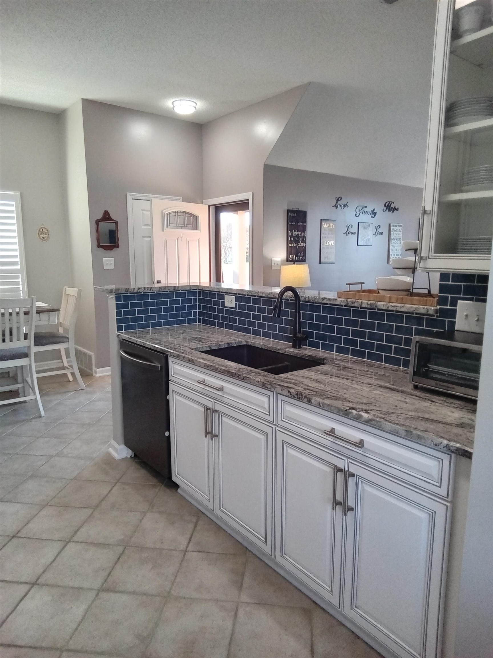 6907 Manslick Road Cordova, TN 38018 - Photo 6 of 24 Kitchen featuring light stone counters, decorative backsplash, black dishwasher, white cabinetry, and light tile patterned flooring