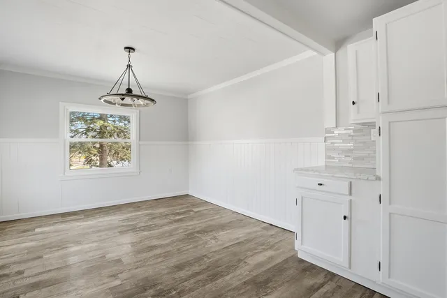 a view of a kitchen with wooden floor and a window