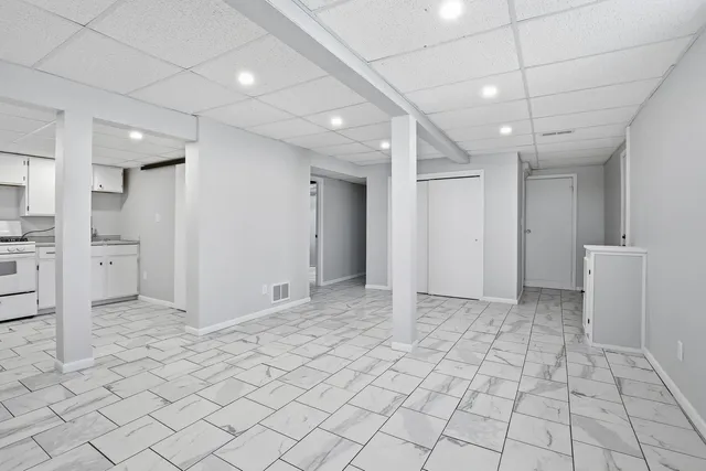 a large white kitchen with a sink and cabinets