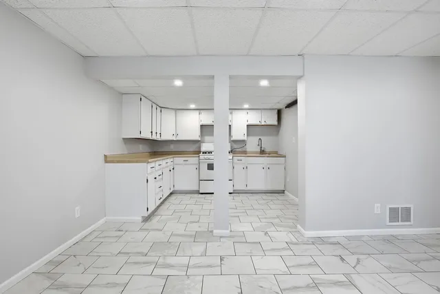 a kitchen with white cabinets appliances and sink