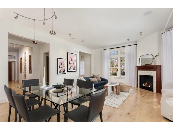 a living room with furniture large window and wooden floor