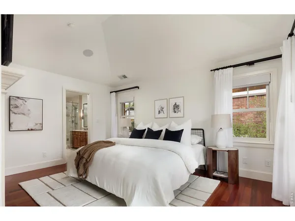 a bedroom with a large bed and a flat screen tv