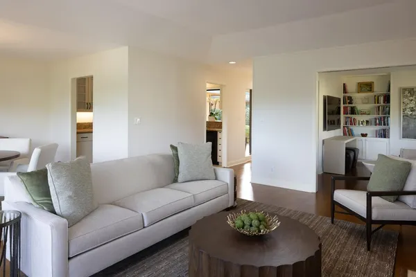 a living room with furniture a rug and a table