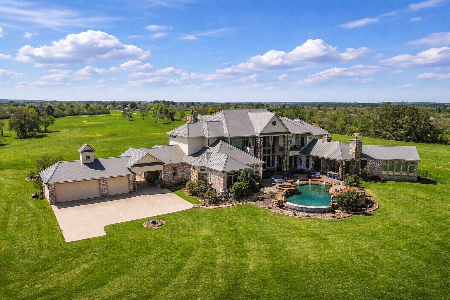460 Bishop Road Huntsville, TX 77320 - Photo 1 of 50 Behind the home lies a sprawling 3,000-acre ranch, offering complete privacy with no neighbors in sight. The property also features a three-car rear-entry garage with a drive-through porte-cochère for added convenience.
