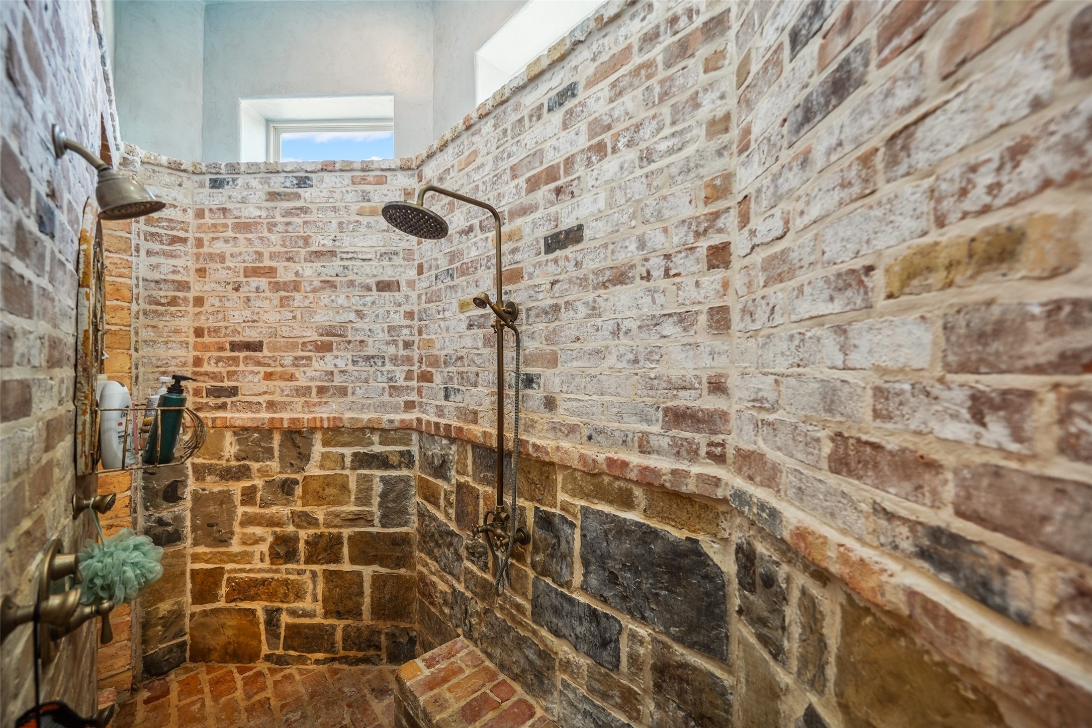 460 Bishop Road Huntsville, TX 77320 - Photo 14 of 50 The spacious walk-through shower, crafted from stone and antique brick, features a premium shower spray system for a truly indulgent experience.