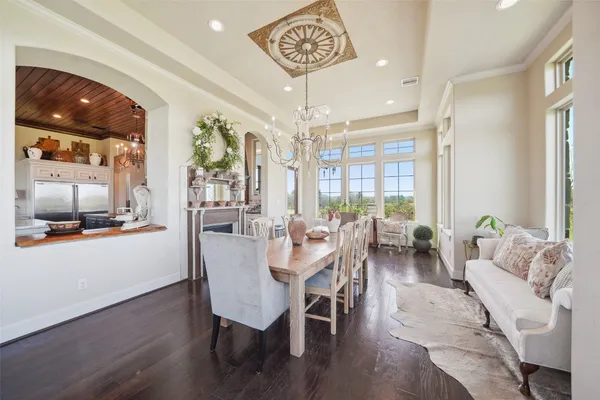 a kitchen with stainless steel appliances granite countertop a refrigerator a sink dishwasher a stove and white cabinets with wooden floor