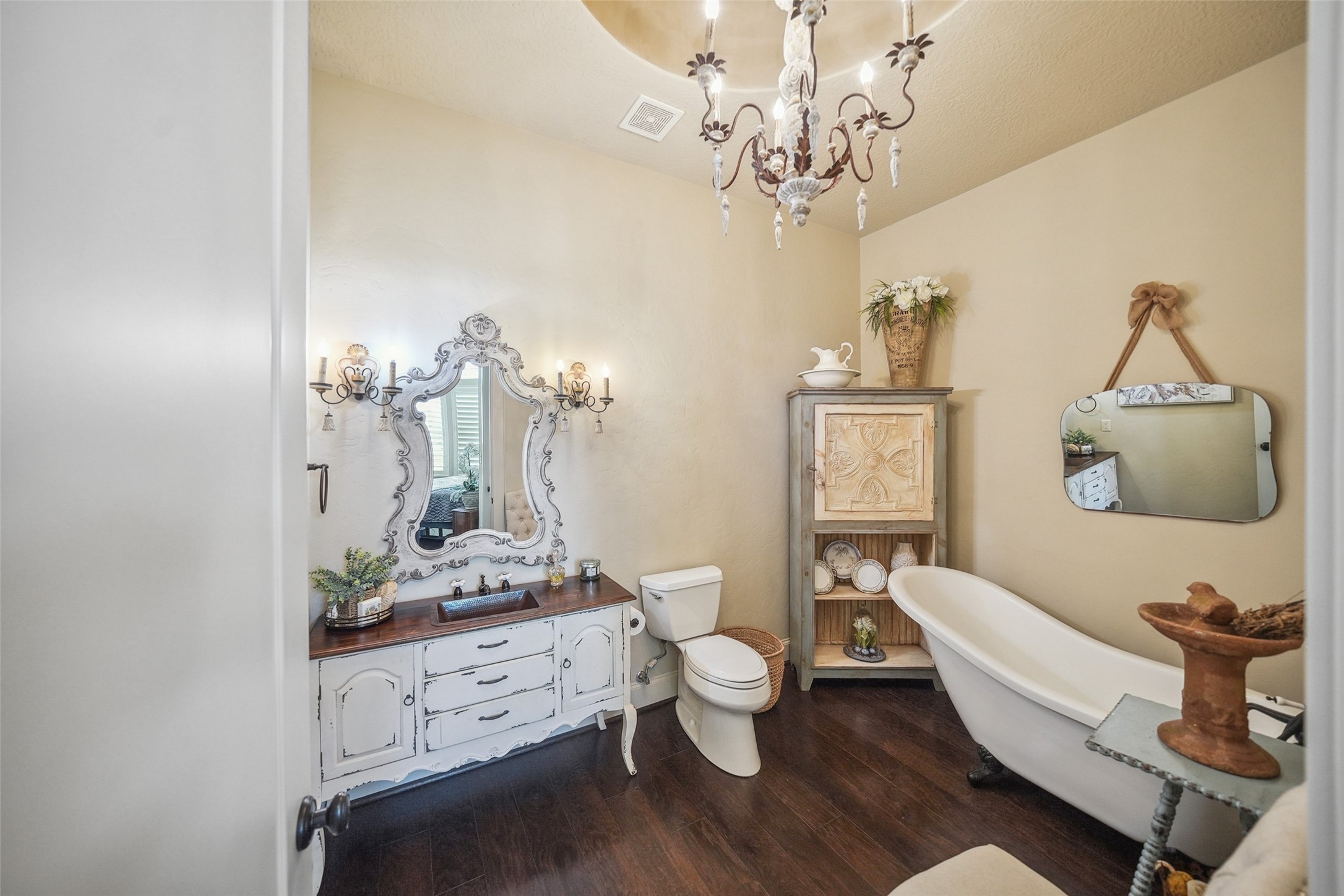 460 Bishop Road Huntsville, TX 77320 - Photo 16 of 50 The ensuite bathroom includes a charming clawfoot tub, while a spacious walk-in closet provides ample storage. Rich hardwood flooring enhances the warmth of the room.