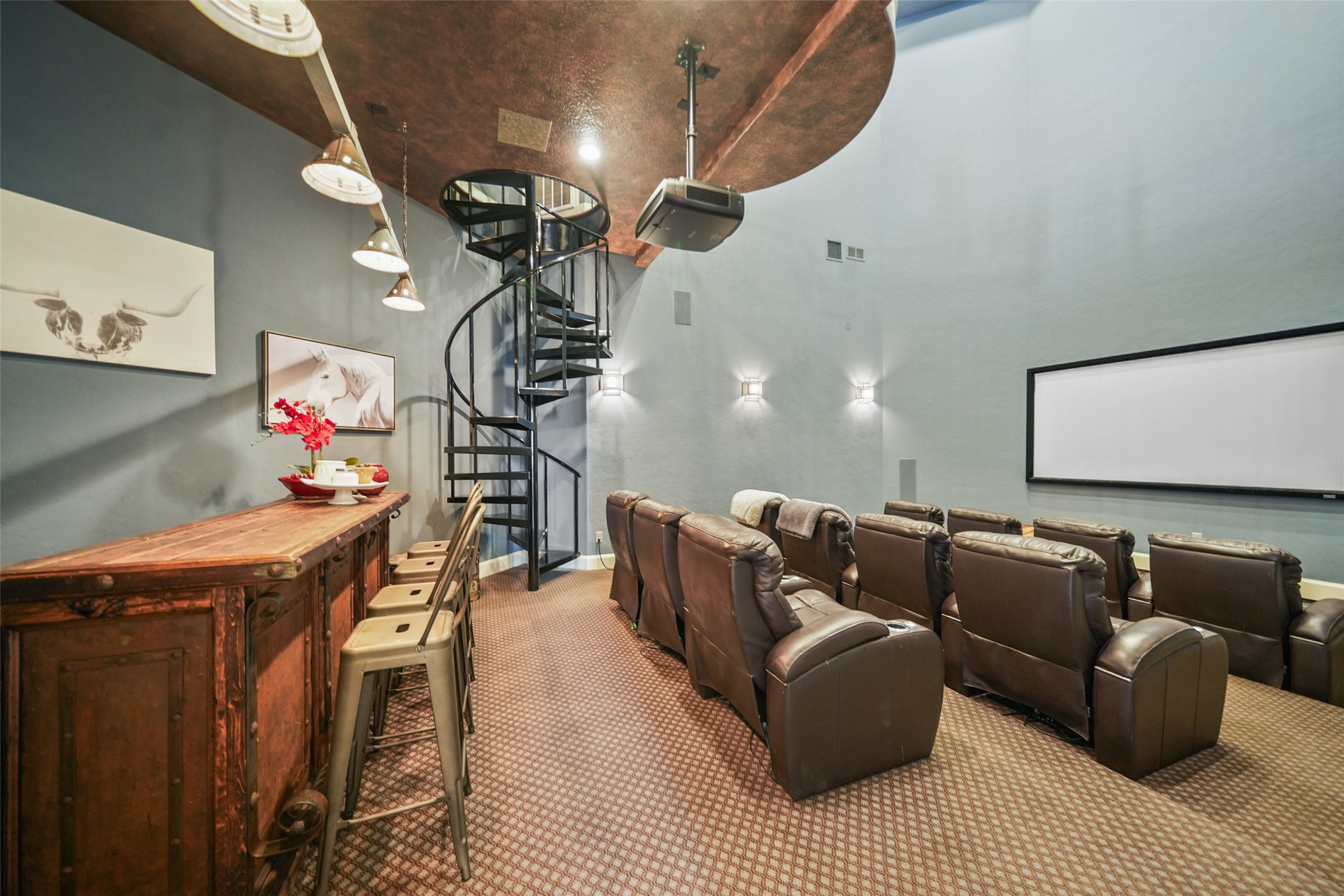 460 Bishop Road Huntsville, TX 77320 - Photo 23 of 50 A three-tiered theater room featuring 11 reclining seats and a large movie screen with a projector. Built-in speakers and a high-quality sound system provide an immersive experience. A spiral staircase leads to the game room above, and the ceiling is elegantly finished with decorative faux painting.