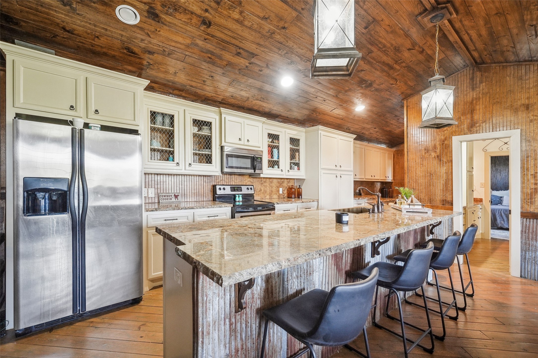 460 Bishop Road Huntsville, TX 77320 - Photo 43 of 50 This spacious kitchen boasts granite countertops, custom cabinetry, and a large island with bar seating, blending modern amenities with rustic charm.