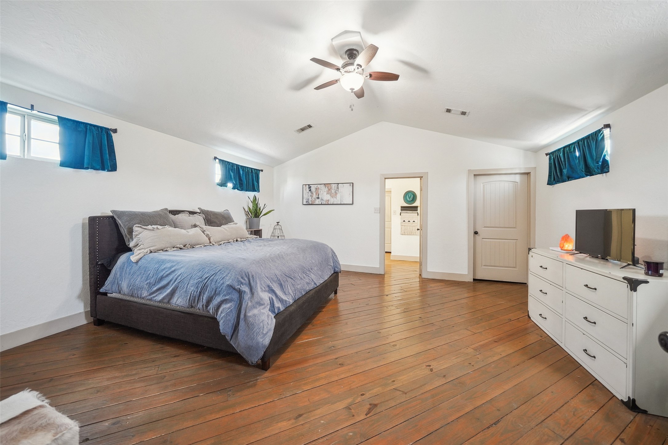 460 Bishop Road Huntsville, TX 77320 - Photo 47 of 50 A cozy and well-lit bedroom featuring stylish decor, a comfortable bed, and large windows that let in plenty of natural light, creating a warm and inviting atmosphere.