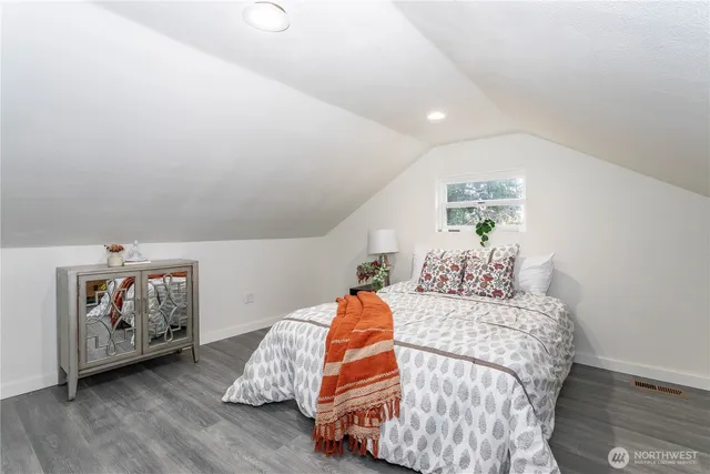 a bedroom with bed and wooden floor