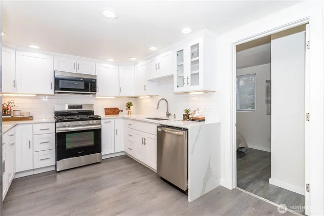 a kitchen with granite countertop a refrigerator and a stove top oven