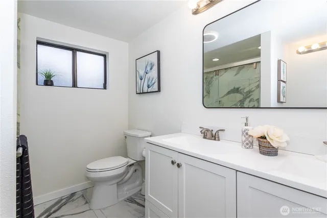a bathroom with a toilet sink and mirror