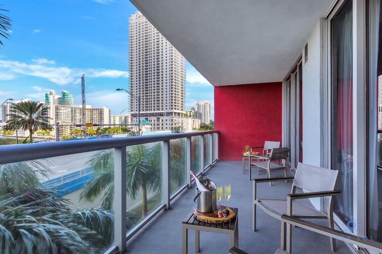 2602 East Hallandale Beach Boulevard, Unit R508 Hallandale Beach, FL 33009 - Photo 12 of 43 a balcony with chairs and table