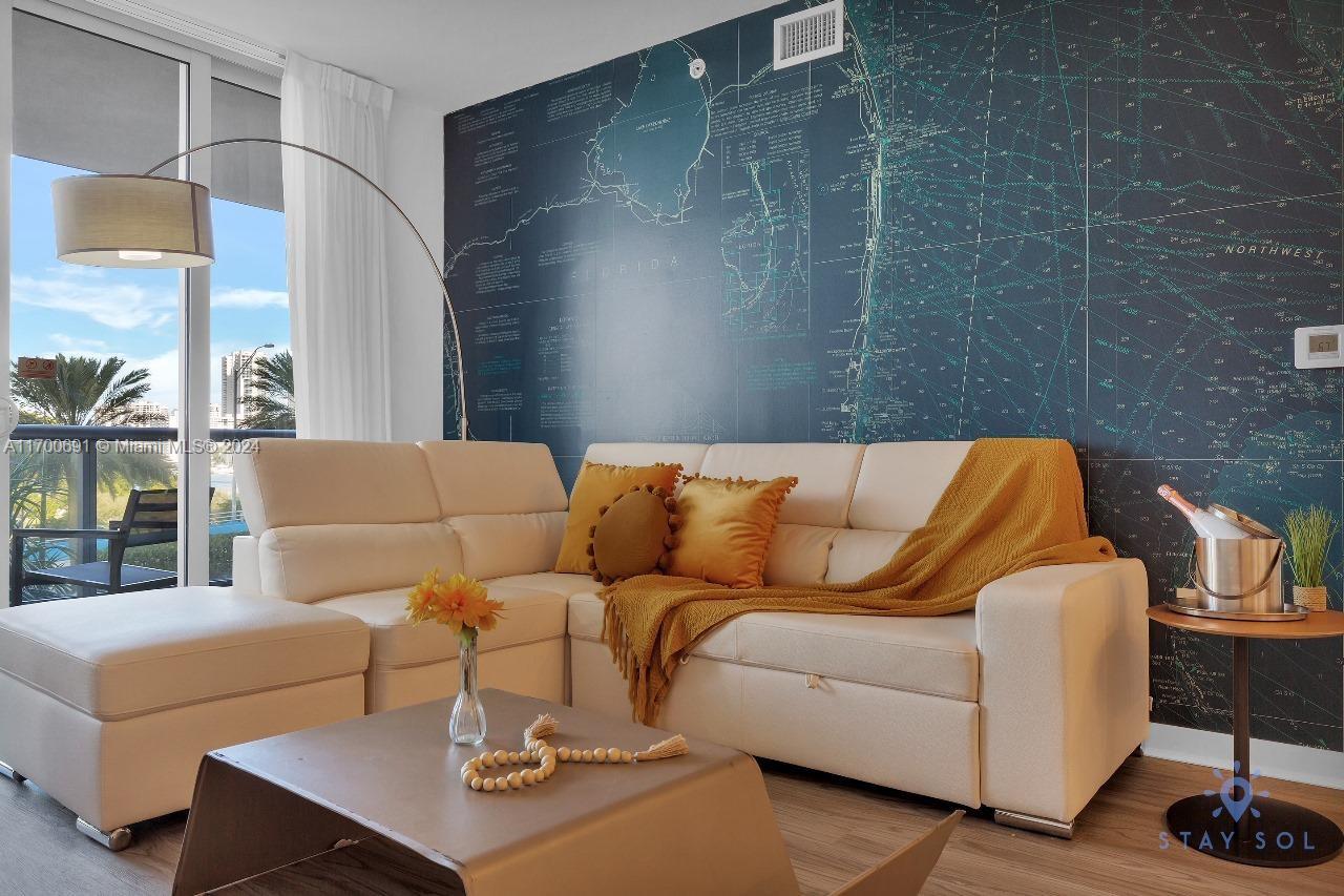 2602 East Hallandale Beach Boulevard, Unit R508 Hallandale Beach, FL 33009 - Photo 34 of 43 a living room with a couch and a table with wooden floor