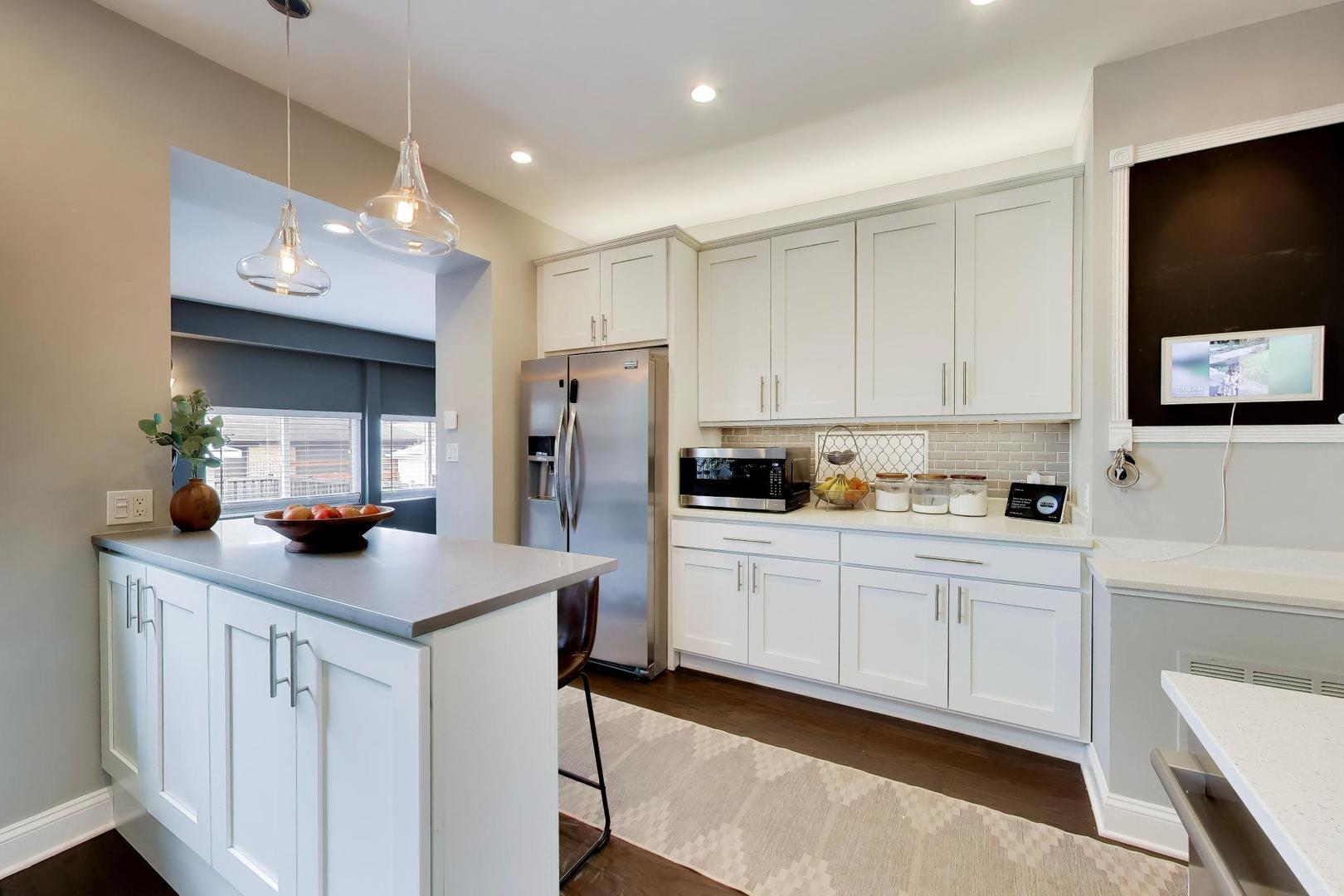 6101 West Patterson Avenue Chicago, IL 60634 - Photo 11 of 40 a kitchen with white cabinets and stainless steel appliances