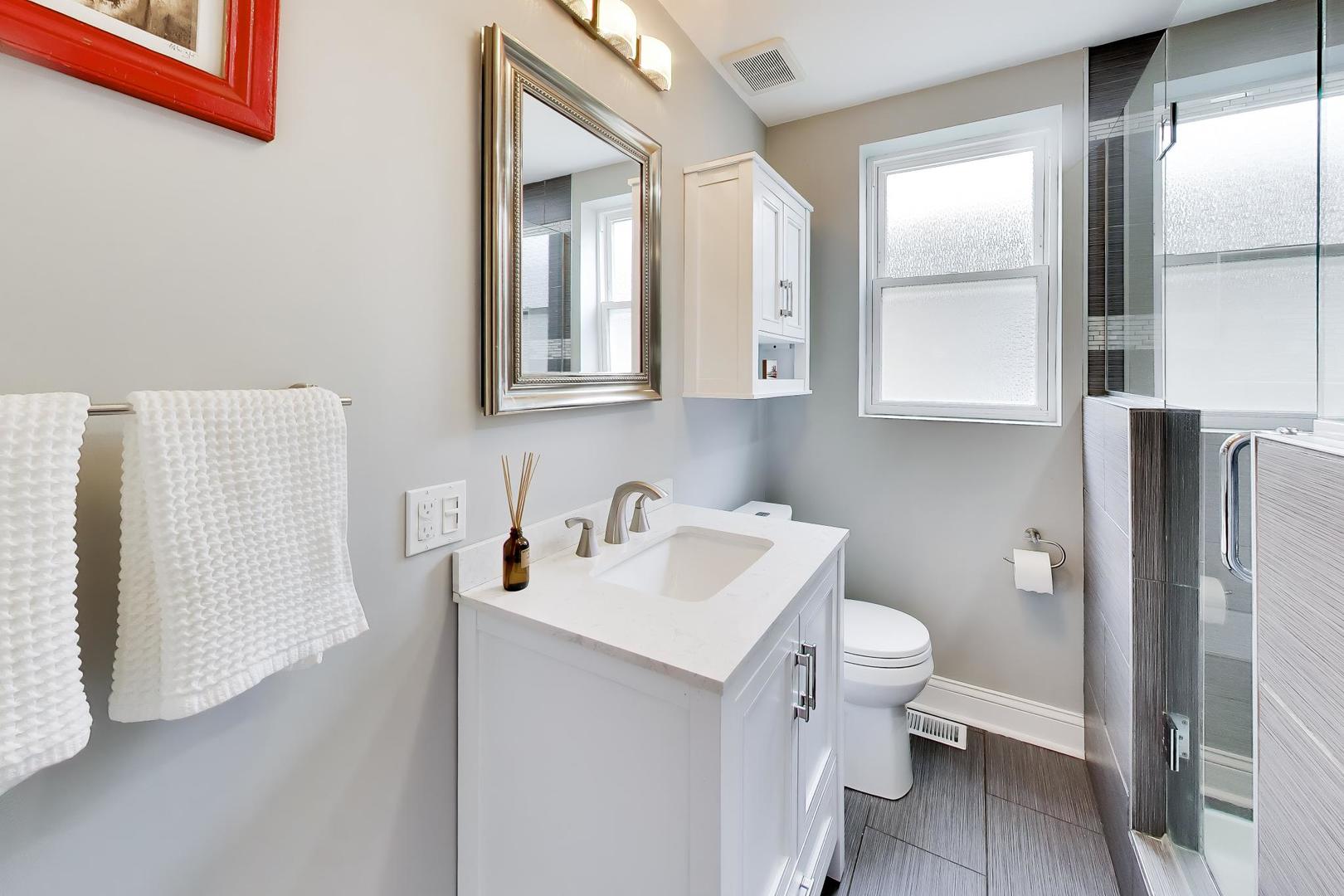 6101 West Patterson Avenue Chicago, IL 60634 - Photo 19 of 40 a bathroom with a toilet sink and mirror