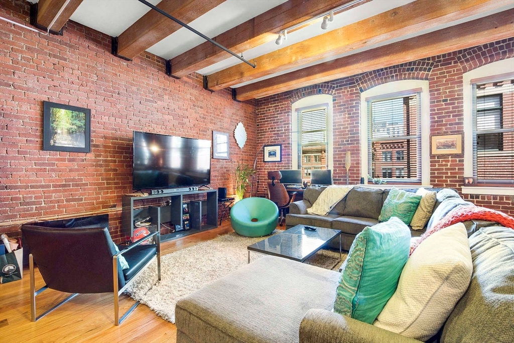 33 Sleeper Street, Unit 508 Boston, MA 02210 - Photo 3 of 11 a living room with furniture and a flat screen tv