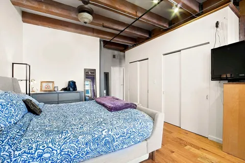 a bedroom with a bed and a flat screen tv