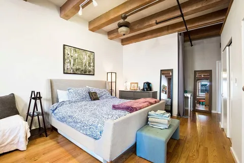 a bedroom with a bed and wooden floor