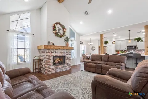 a living room with furniture a fireplace and a large window