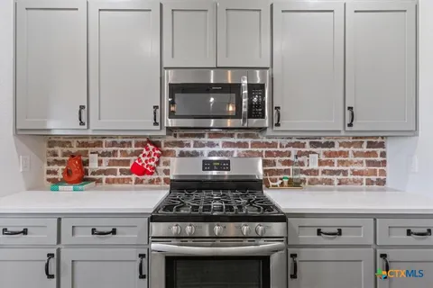 a kitchen with kitchen island granite countertop a sink stainless steel appliances and cabinets