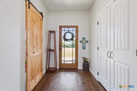 a view of a hallway with wooden floor and entryway